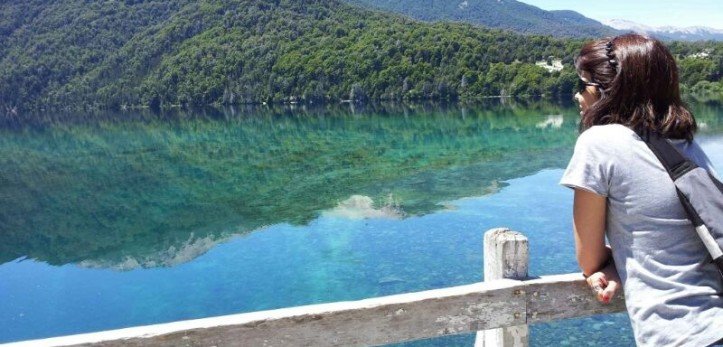 mulher observa um lago espelhado